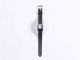 a close up of a watch on a white surface with a black strap