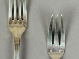 two forks and a spoon on a table