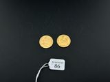 a close up of two gold coins on a black surface