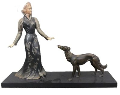 statue of a woman and a dog on a black base