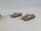 three toy tanks are sitting on a white surface with a white background