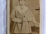 an old photo of a man in a priest ' s robes