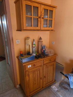 une armoire en bois avec des portes vitrées dans une cuisine