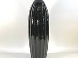 a black vase sitting on top of a white table