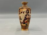a small vase with a painting on it sitting on a table