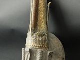 statue of a man holding a knife on top of a metal object