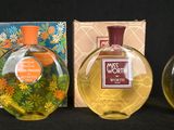 three bottles of perfume sitting next to each other on a black surface