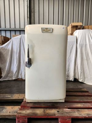 a white refrigerator sitting on a pallet in a warehouse