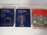Trois livres sont posés sur une table, avec une tour horloge en arrière-plan.