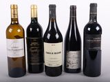 plusieurs bouteilles de vin sont alignées sur une surface blanche