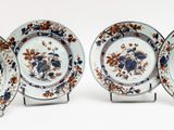 four plates with floral designs on them on a white surface