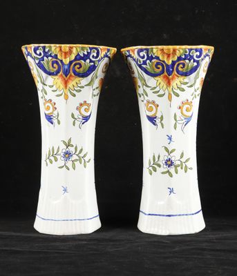 deux vases blancs ornés de motifs bleus et jaunes sur fond noir
