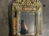 a mirror hanging on the wall with a person taking a picture