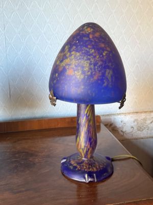 a purple lamp that is sitting on a wooden table
