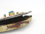 a silver and gold broochee with a boat on it