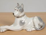 porcelain figurine of a dog laying down on a wooden table