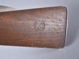 an old gun with a wooden handle on a white surface
