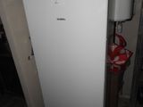 a white refrigerator in the corner of a room with a fire hydrant in the corner