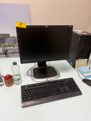 un écran d'ordinateur, un clavier, une souris et d'autres fournitures de bureau posés sur un bureau
