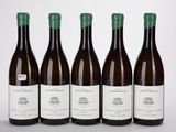 quatre bouteilles de vin sont alignées sur une surface blanche
