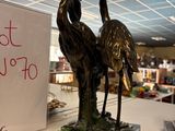 a statue of two birds on a table with a sign in the background
