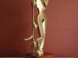 statue of a woman holding a cat on a wooden base