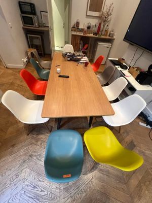 brightly colored chairs sit around a wooden table in a room