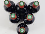 six bottles of wine are arranged in a circle on a white surface