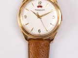 a brown strap on a watch that is hanging on a wall