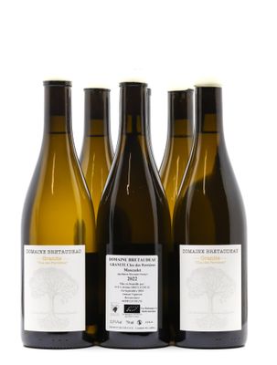 trois bouteilles de vin posées les unes à côté des autres sur une surface blanche