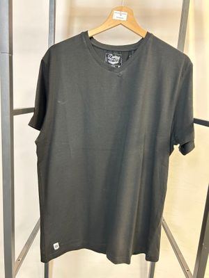 un t-shirt gris suspendu à un portemanteau dans un magasin de vêtements