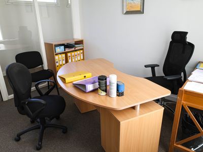 a desk with a chair and a book shelf in the corner