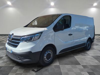 une camionnette blanche garée dans une pièce au sol en damier