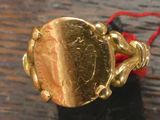 une bague en or entourée d'un fil rouge