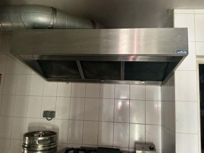 a stainless steel stove top in a white tiled kitchen