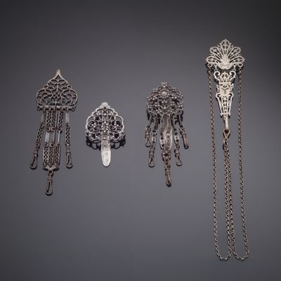 three silver brooches and a chain necklace