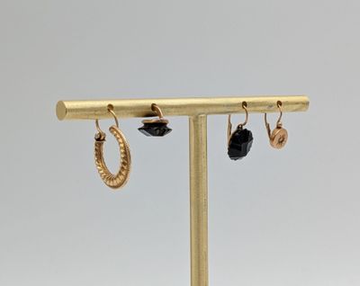 a close up of a pair of earrings on a stand