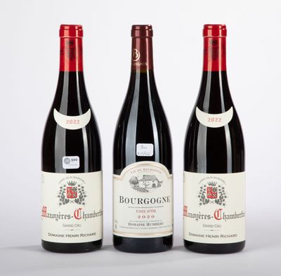 trois bouteilles de vin rouge posées l'une à côté de l'autre sur une surface blanche