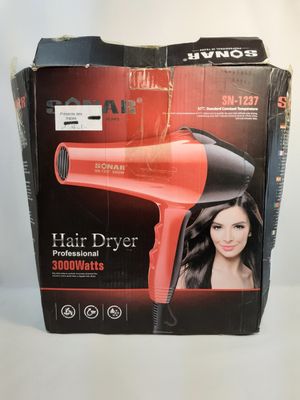 La boîte d'un sèche-cheveux est ouverte sur la table.