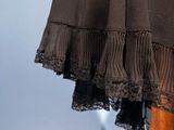 a close up of a woman ' s brown skirt with black lace on it