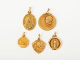 quatre médailles d'or sur lesquelles figurent l'image d'un homme et d'une femme