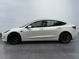 a white tesla model 3 parked in a garage