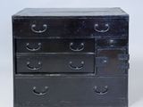 une petite commode noire sur fond blanc