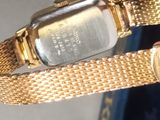 a person holding a gold watch with a gold band