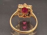 an image of a close up of a gold ring with a ruby stone