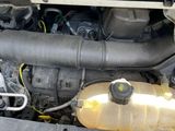 a car engine with a yellow tank in the trunk of it