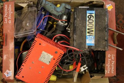 une boîte remplie de matériel électrique divers, posée par terre