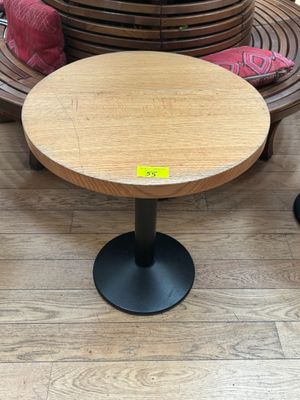 une table en bois avec un piètement en métal noir posée sur un parquet