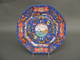 une assiette bleue et orange sur laquelle est représenté un oiseau