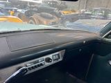 a dashboard of a car in a parking lot with other cars in the background